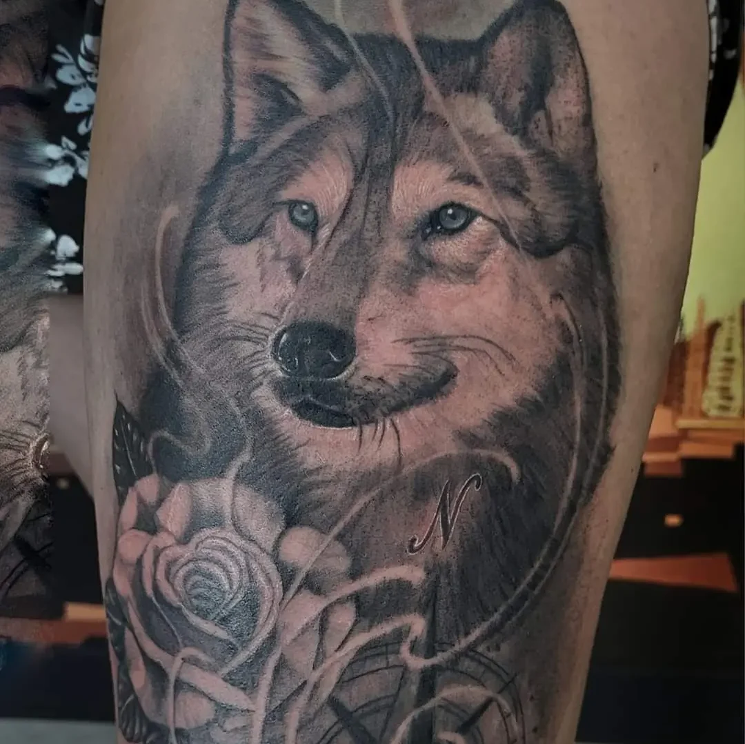 black and grey wolf tattoo with compass